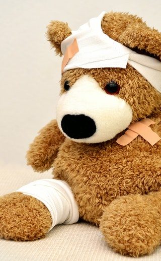 a brown stuffed bear with bandages