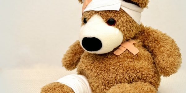 a brown stuffed bear with bandages