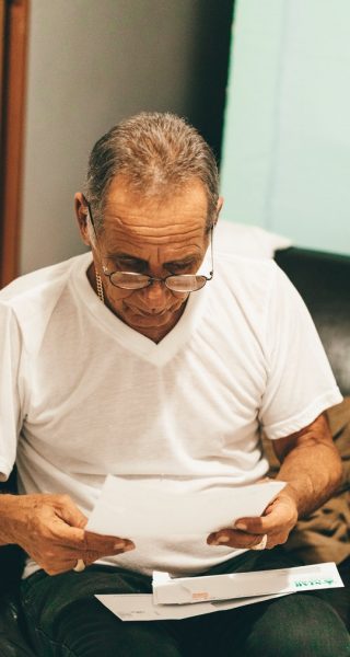 an old man holding and reading a piece of paper