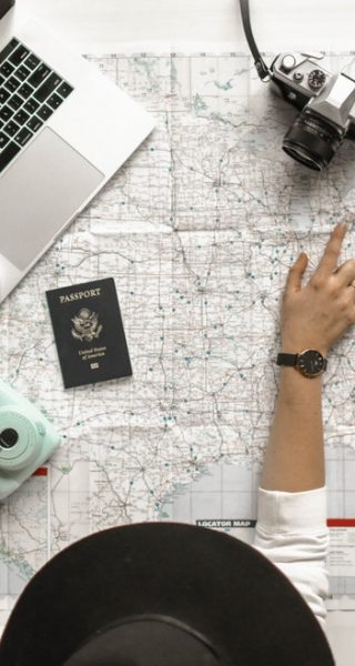 electronic devices and passport over a world map used for travel planning