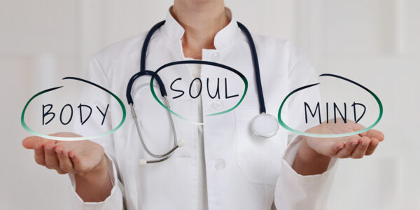 a doctor holding a sign of balancing body, soul, mind